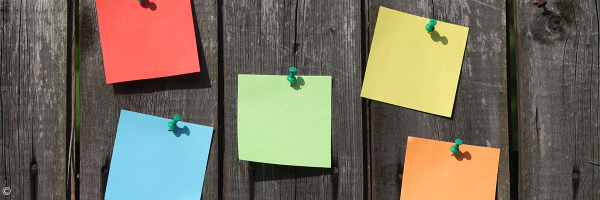 Bunte Notizzettel an einer Holzwand